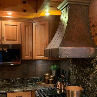 Sinda hammered traditional custom range hood installed in kitchen
