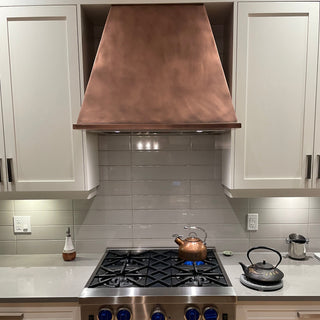 Modern kitchen with stainless steel stove and copper hood