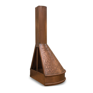 a copper range hood with a tall vertical chimney and a decorative beaded base, featuring embossed floral and mountain motifs on the front panel