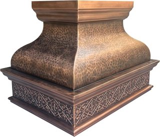 Decorative range hood with textured surface and intricate patterns on a white background