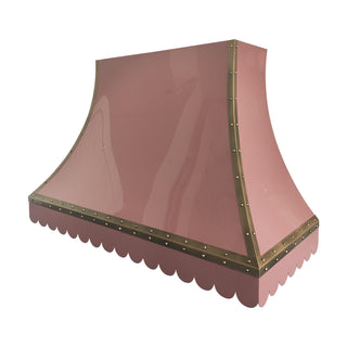 a pink stainless steel range hood cover with a scalloped lower edge and brass-colored riveted trim