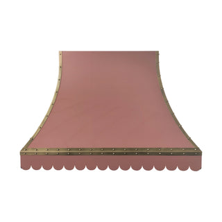 a scalloped pink stainless steel range hood with brass trim and rivets