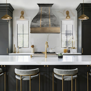 Modern kitchen with black cabinets, white countertops, and elegant zinc range hood