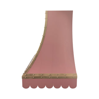 a custom pink stainless steel range hood with gold brass trim and decorative rivets