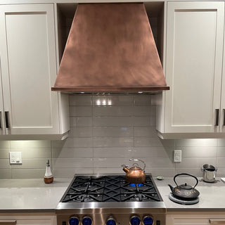 Modern kitchen with stainless steel stove and copper hood
