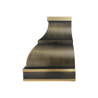 the side of a tiered antique brass stove vent hood with a brushed brass straps