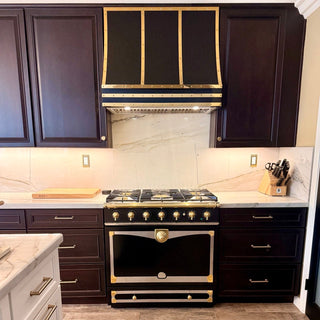 a luxury black and gold freestanding gas range with a matching stainless steel range hood, installed in a modern kitchen