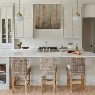 Luxury kitchen with aged brass range hood.