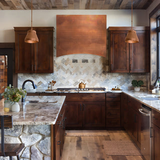A traditional kitchen with reddish-brown woodencabinets, fired copper range hood.