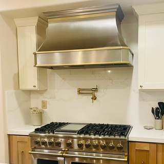 Stainless steel range hood above a gas stove in a modern kitchen