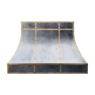 Front view: Non-directional zinc range hood framed with aged brass straps and round rivets.