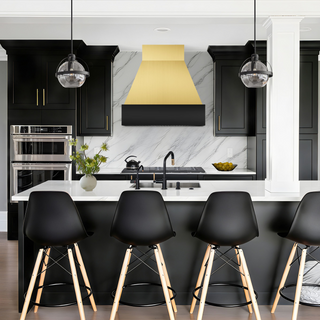 Modern kitchen with brushed brass and black stainless steel range hood.