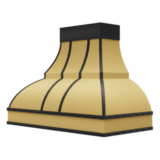Angled view of a brushed brass range hood: Tapers top-to-bottom with a curved base, featuring brushed stainless steel straps and round rivets.