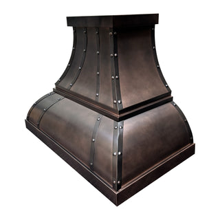 Right front view of antique copper arch bell range hood featuring strap-mounted round rivets.