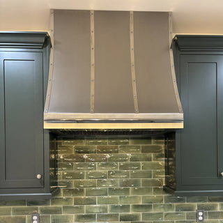 A stainless- steel kitchen range hood with a classic canopy shape