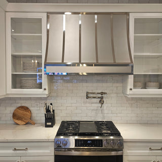 modern kitchen with stainless steel range hood, stove, and white cabinets