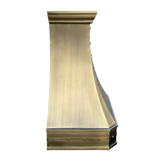 the side of a curved antique brass kitchen range hood